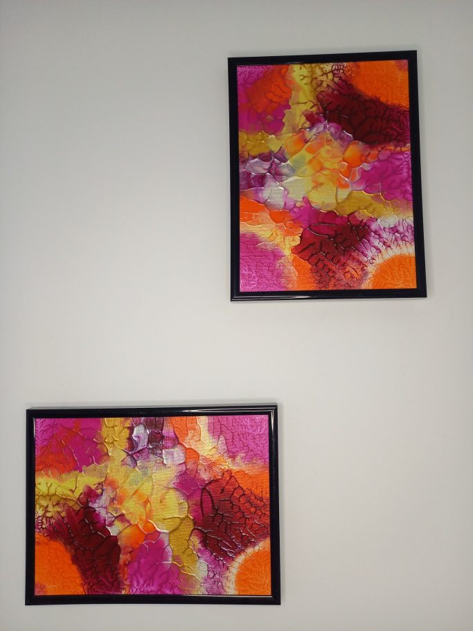 " Aurore tropicale" Deux cadres accrochés au mur, contenant des œuvres abstraites colorées en rose, orange et jaune.