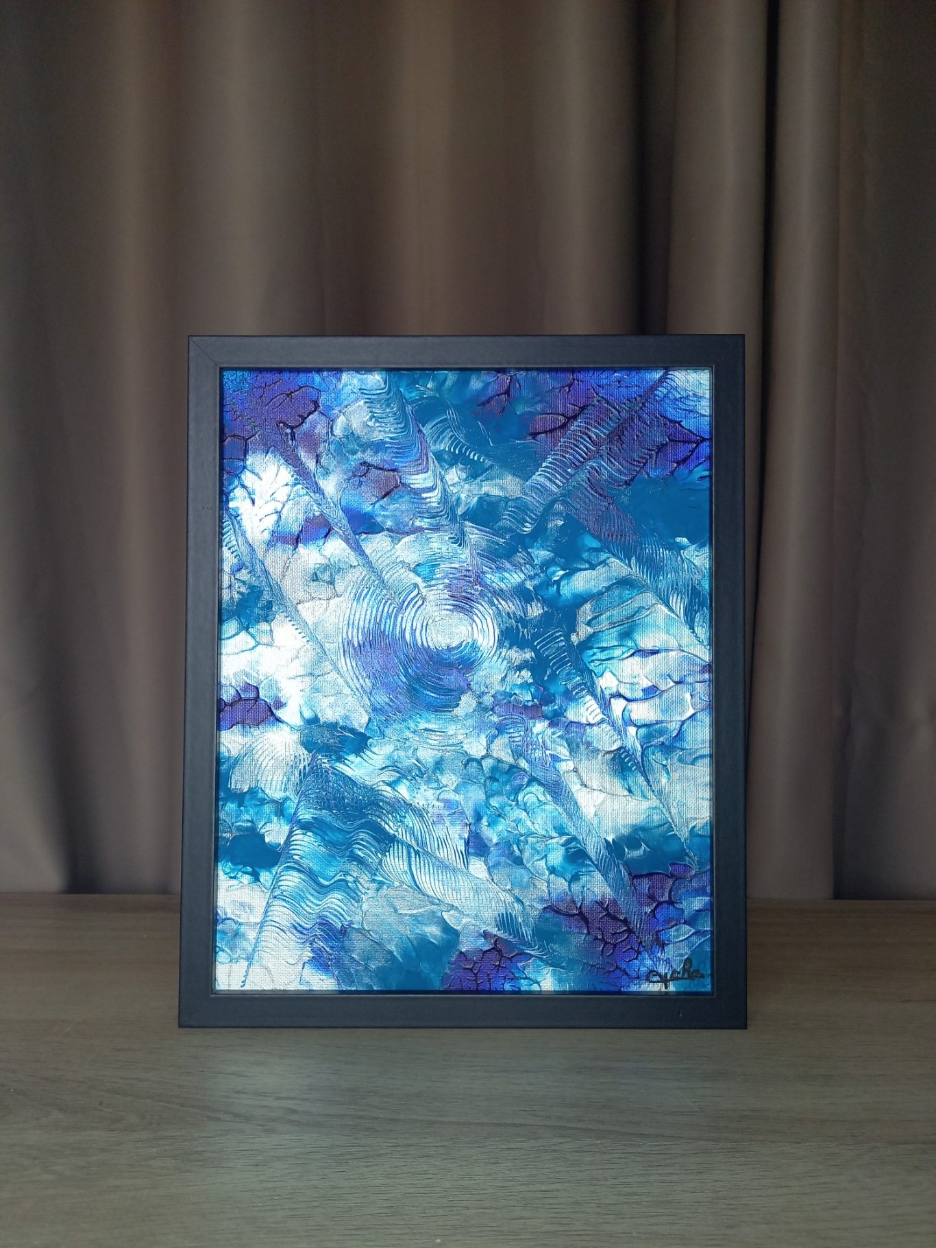 "Échos marins" Peinture abstraite aux nuances de bleu et violet, encadrée, sur fond neutre.