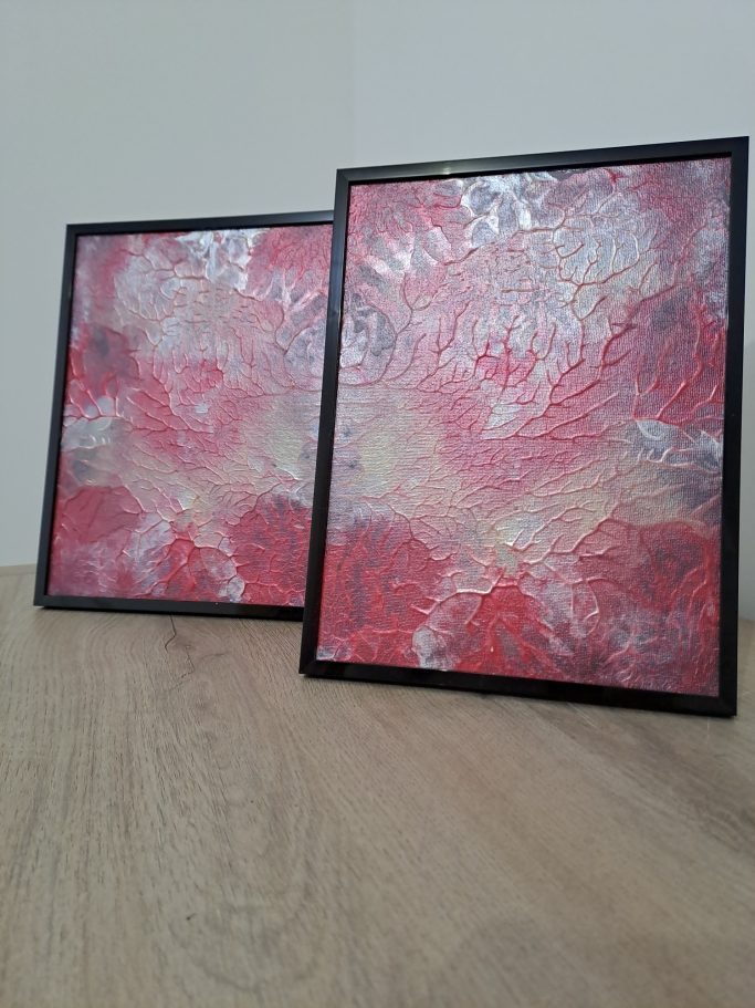 "Pulsation" Deux tableaux encadrés avec des motifs abstraits rouges et dorés sur fond clair.