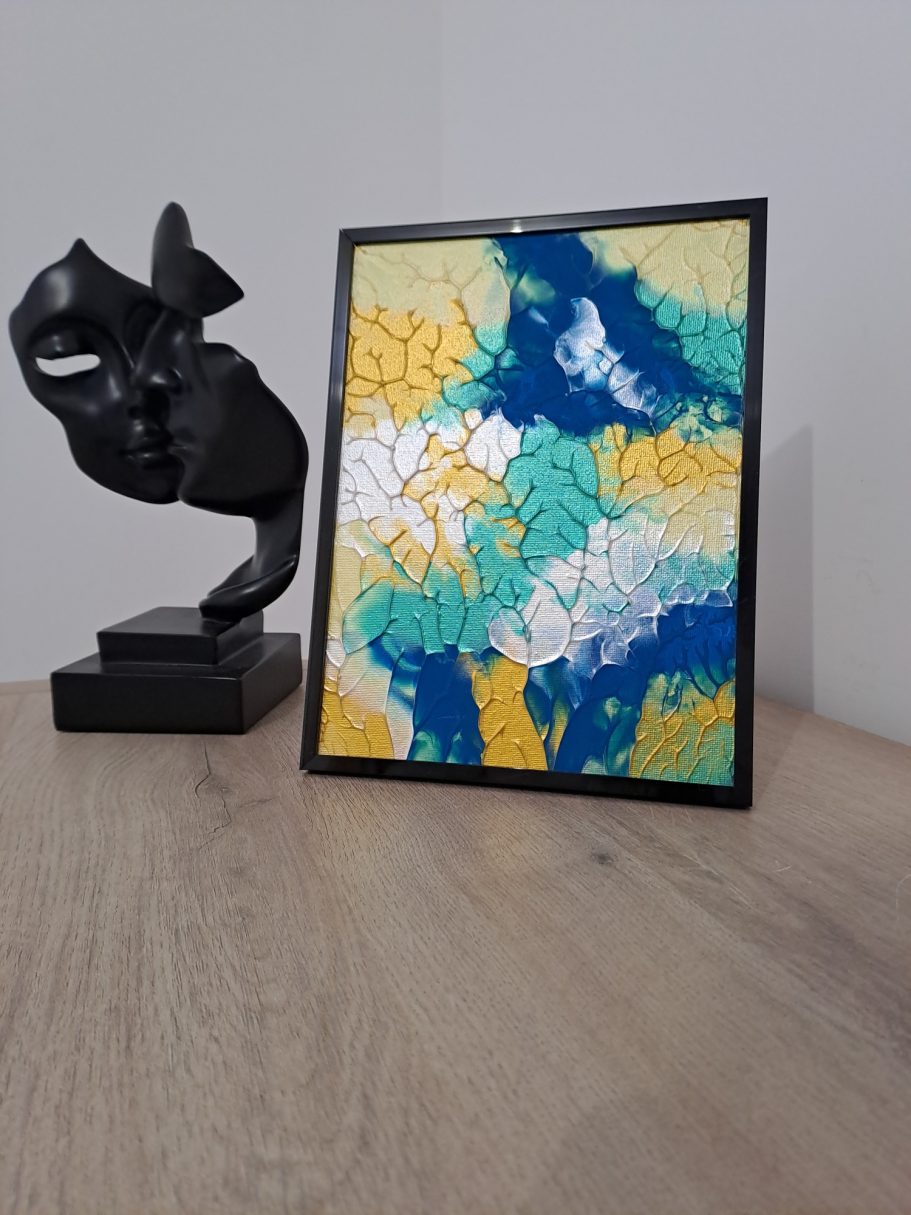 "Lagune solaire" Carte colorée avec des motifs en relief, à côté d'une sculpture abstraite noire.