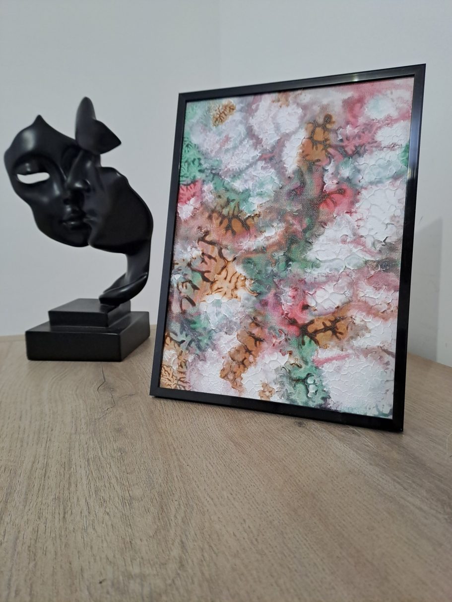 "Floraison antique V1" Table avec une sculpture noire et un cadre affichant un motif coloré.