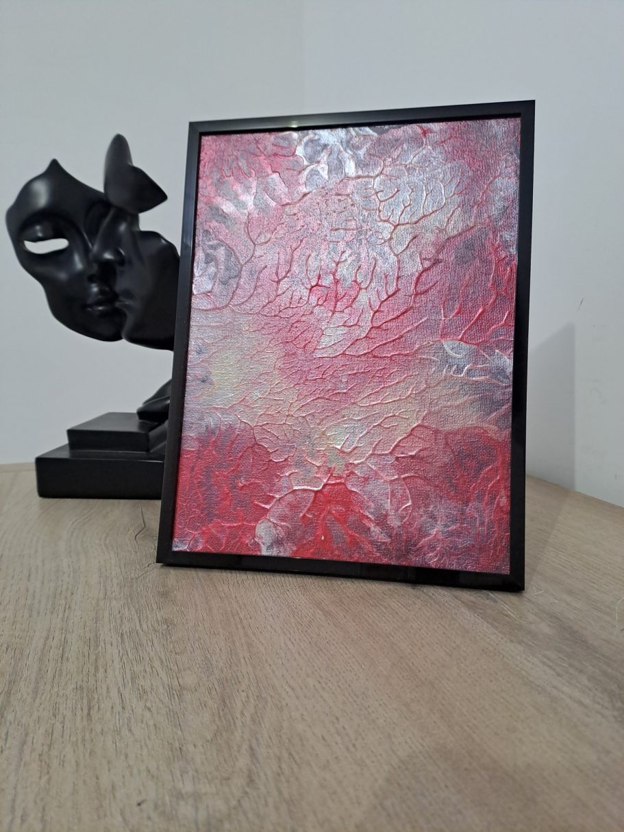 "Pulsation" Œuvre d'art abstrait aux teintes rouges, avec une sculpture noire en arrière-plan.